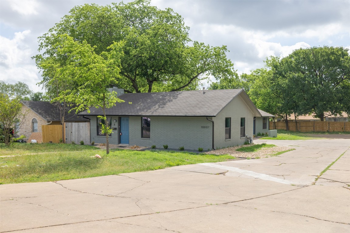 10007 Quail Valley Boulevard, Unit A Austin, TX 78758 - Photo 1 of 13 a front view of a house with a yard and garage