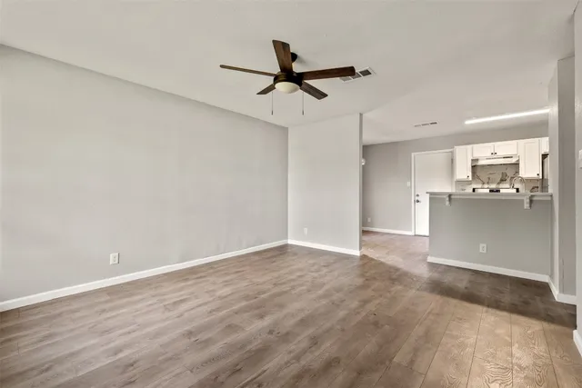 a view of a kitchen with a sink and wooden floor