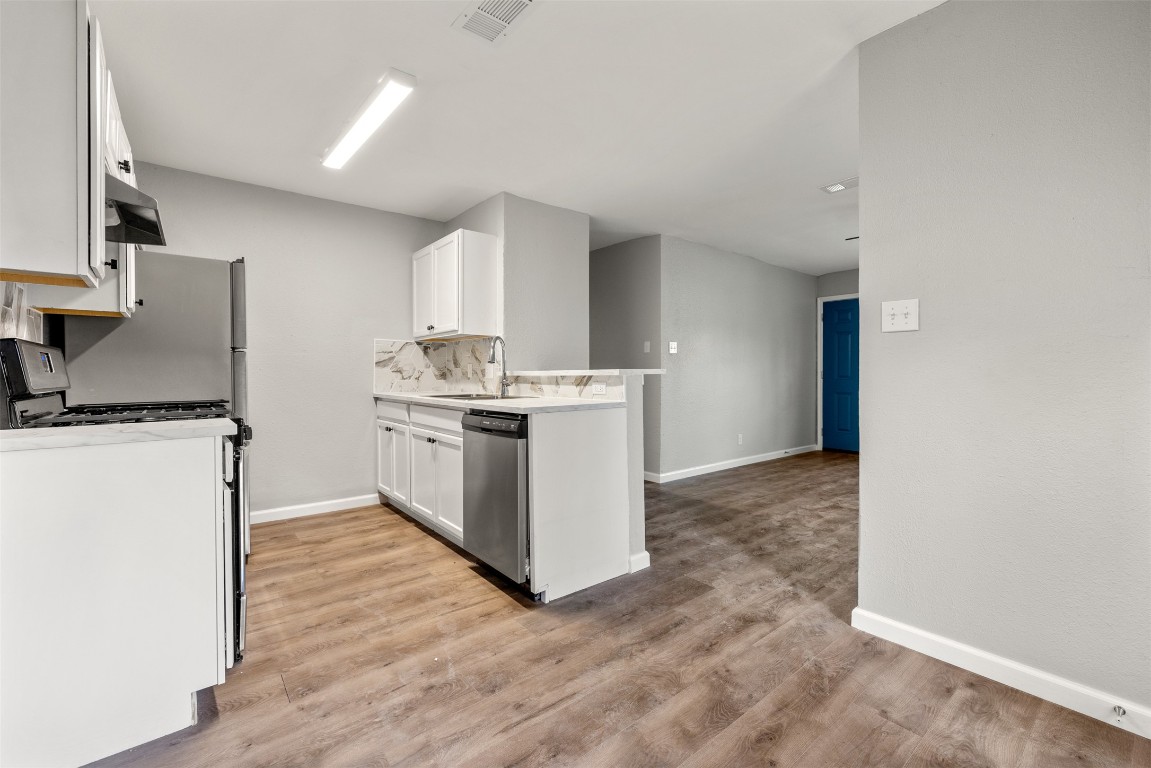 10007 Quail Valley Boulevard, Unit A Austin, TX 78758 - Photo 5 of 13 a kitchen with a stove top oven and cabinets