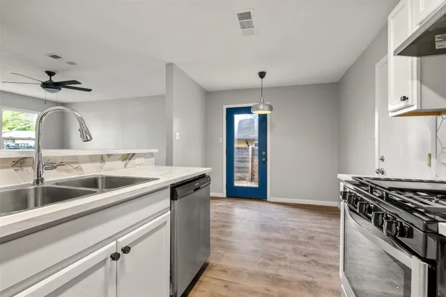 a kitchen with stainless steel appliances granite countertop a sink and a stove