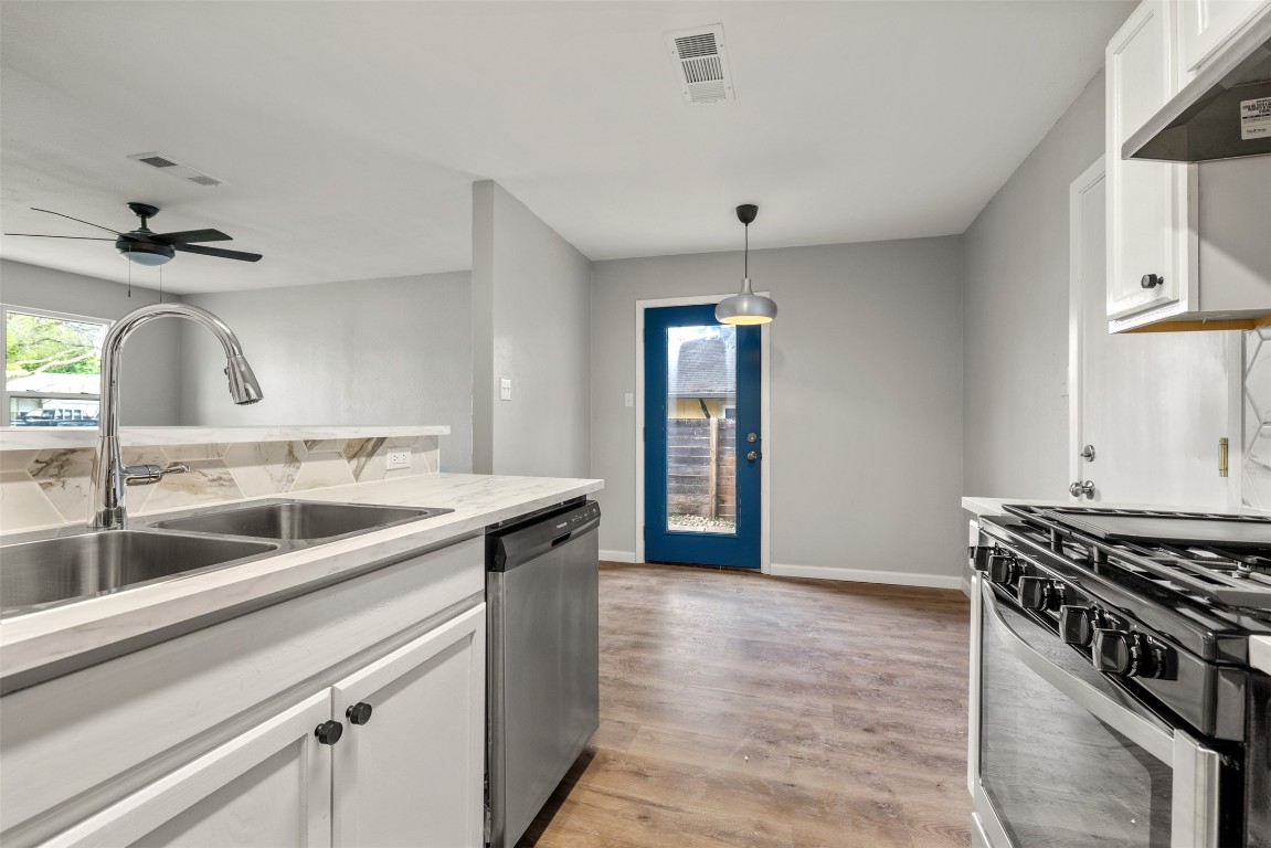 10007 Quail Valley Boulevard, Unit A Austin, TX 78758 - Photo 6 of 13 a kitchen with stainless steel appliances granite countertop a sink and a stove