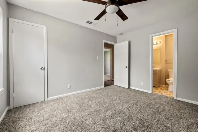 an empty room with fan and entryway