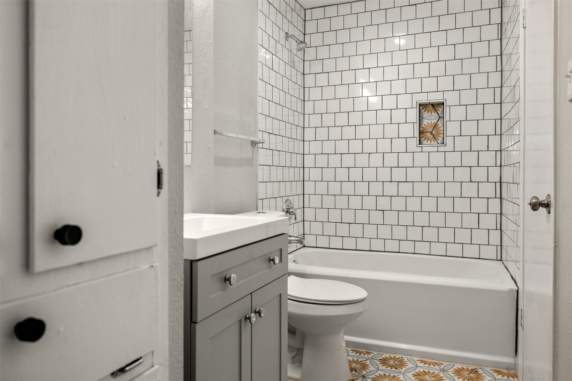10007 Quail Valley Boulevard, Unit A Austin, TX 78758 - Photo 10 of 13 a bathroom with a granite countertop bathtub and toilet