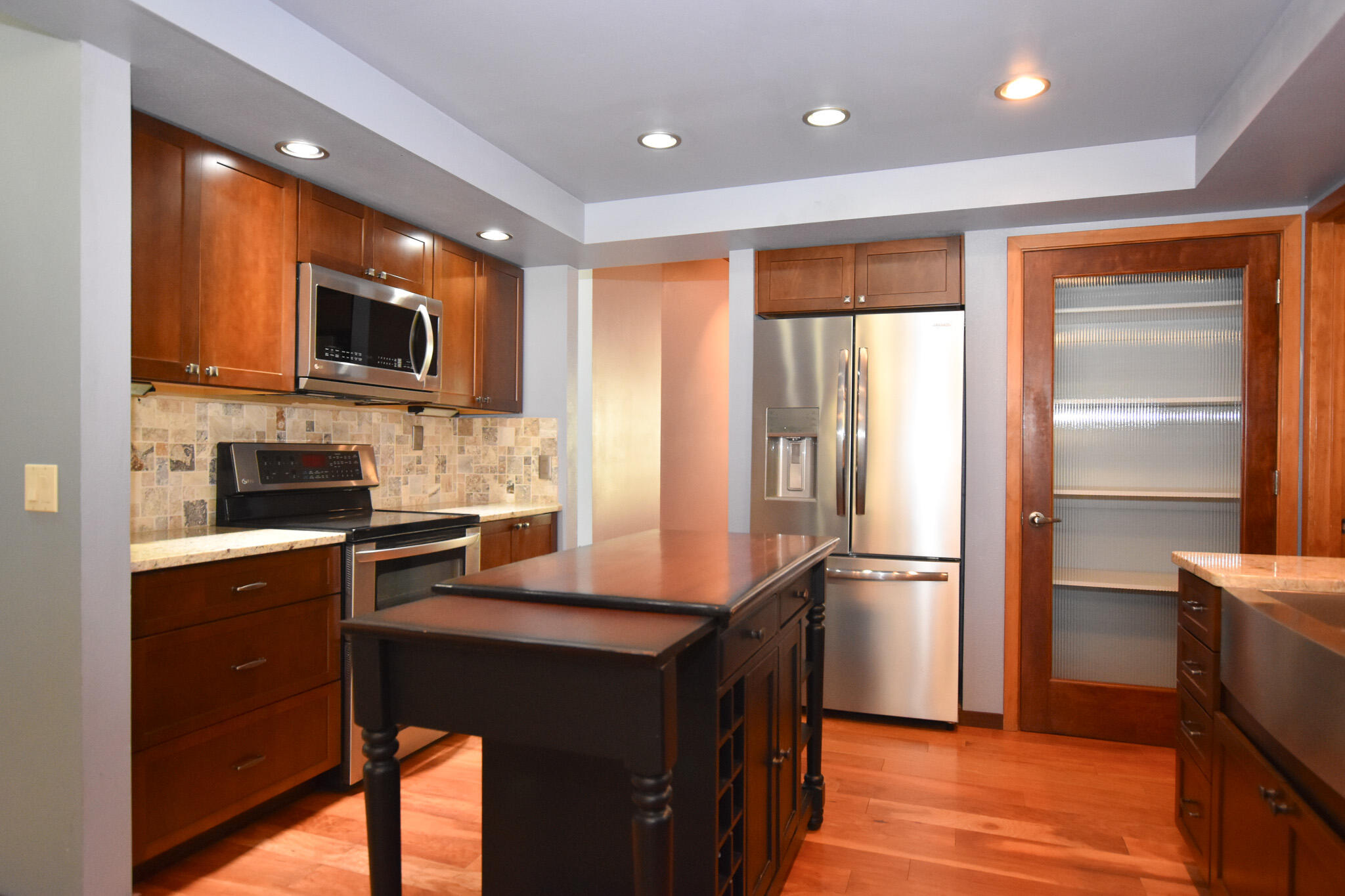 64730 Sylvan Loop Bend, OR 97701 - Photo 22 of 46 a kitchen with a refrigerator a microwave a sink and cabinets