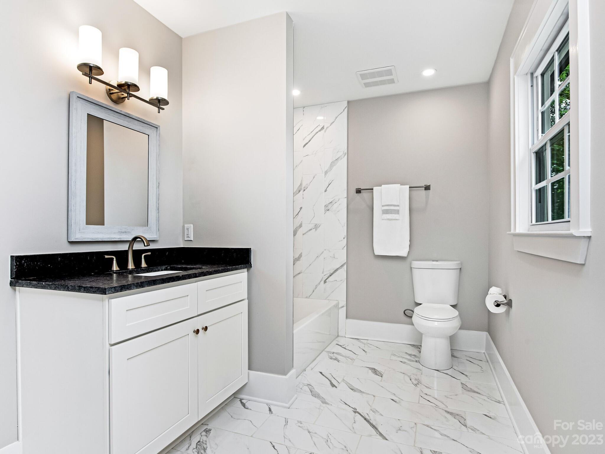 1815 Harris Road Charlotte, NC 28211 - Photo 24 of 32 a bathroom with a granite countertop sink a toilet and a mirror