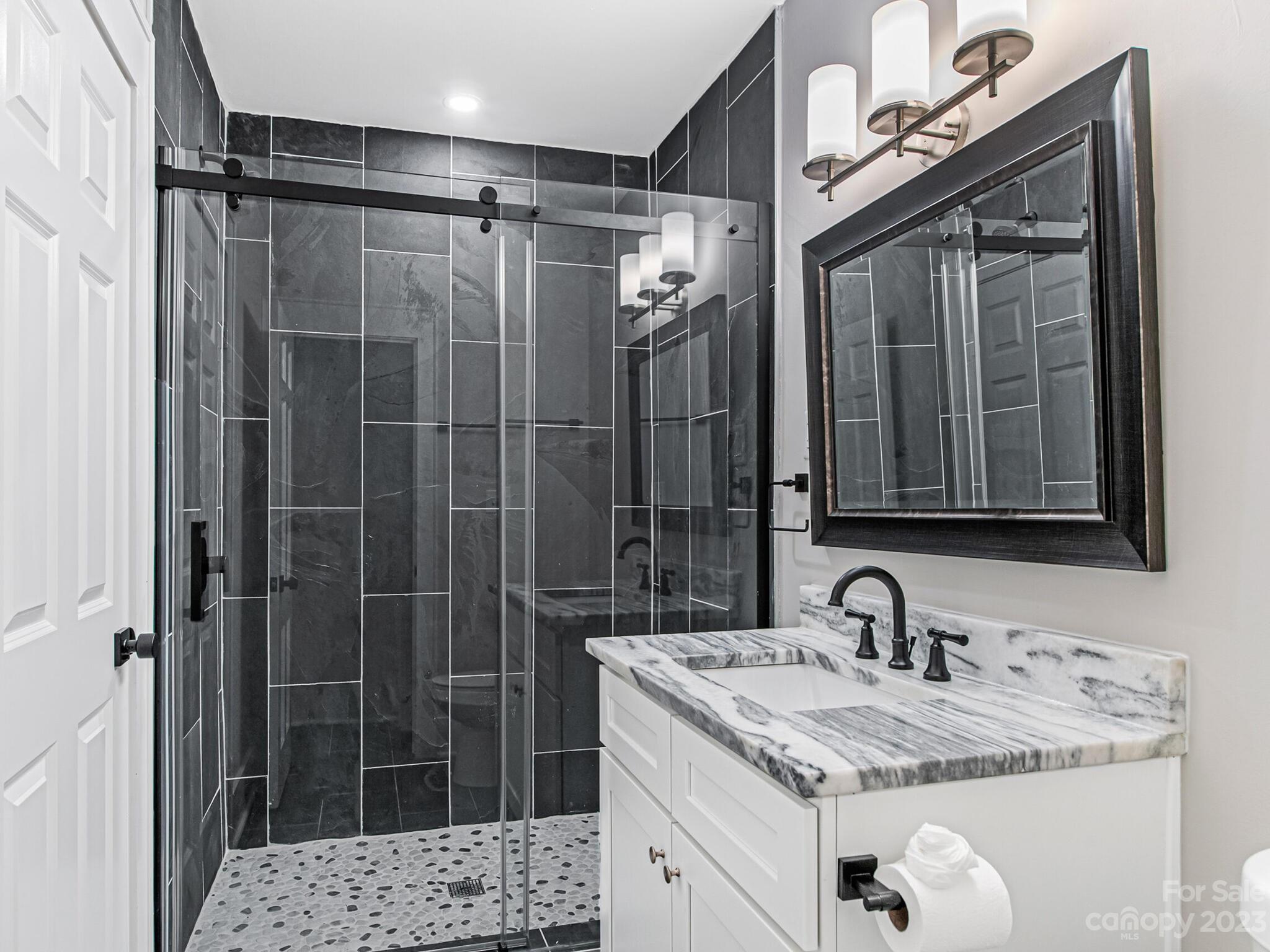1815 Harris Road Charlotte, NC 28211 - Photo 28 of 32 a bathroom with a granite countertop sink a mirror a vanity and shower
