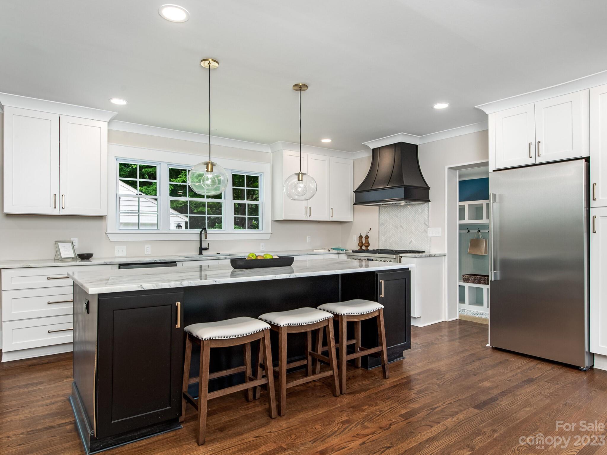 1815 Harris Road Charlotte, NC 28211 - Photo 6 of 32 a kitchen with stainless steel appliances granite countertop a sink a stove a refrigerator and island with wooden floor