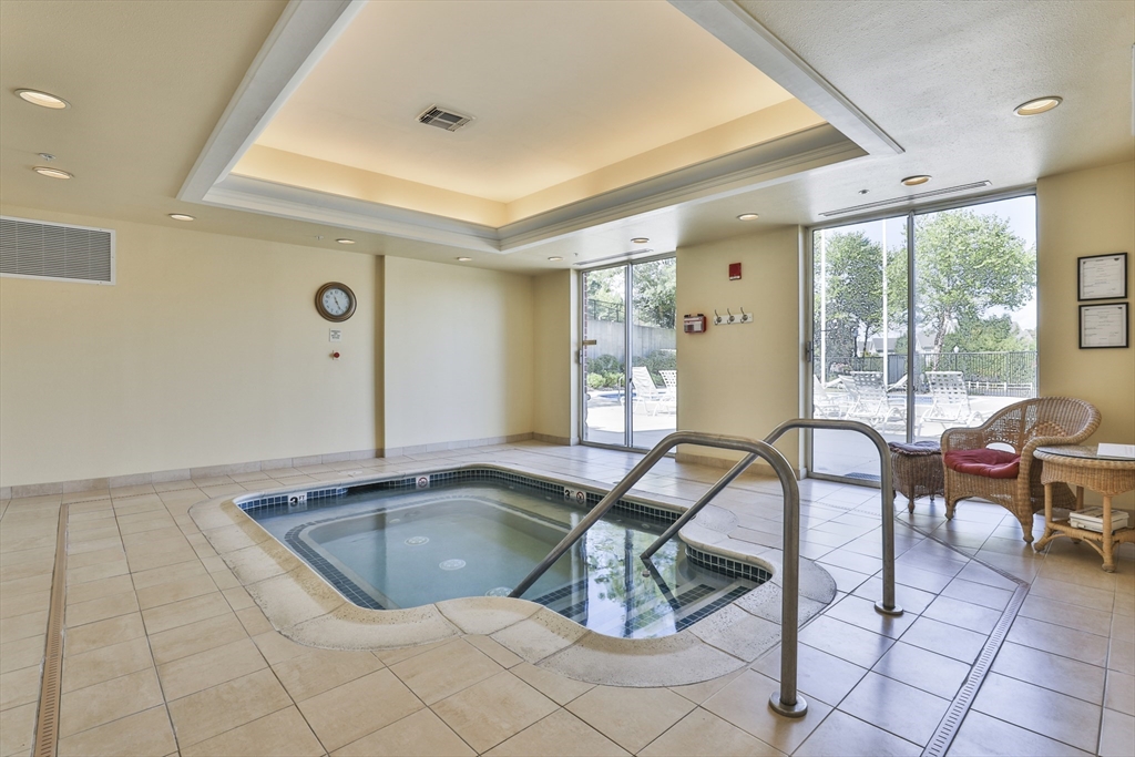 38 Village Road, Unit 602 Middleton, MA 01949 - Photo 40 of 42 a view of a swimming pool and lounge chair