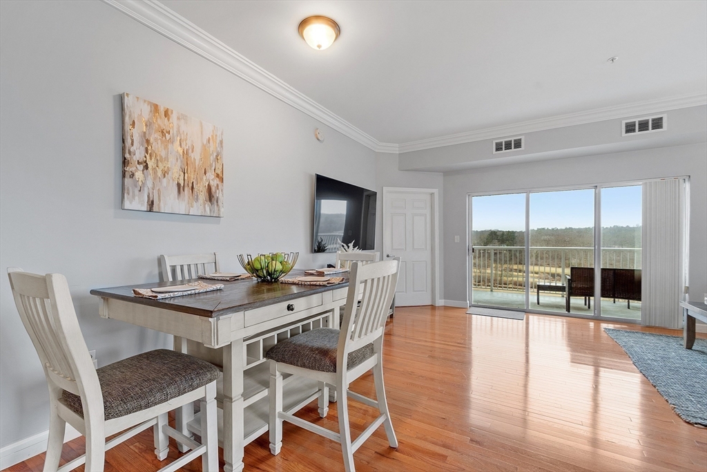 38 Village Road, Unit 602 Middleton, MA 01949 - Photo 4 of 42 a dining room with furniture and wooden floor