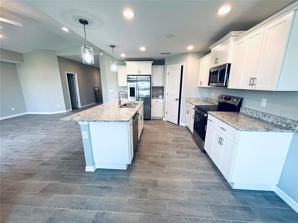 415 Baytree Drive Rotonda West, FL 33947 - Photo 3 of 3 a large kitchen with stainless steel appliances kitchen island granite countertop a large counter top and a stove top oven