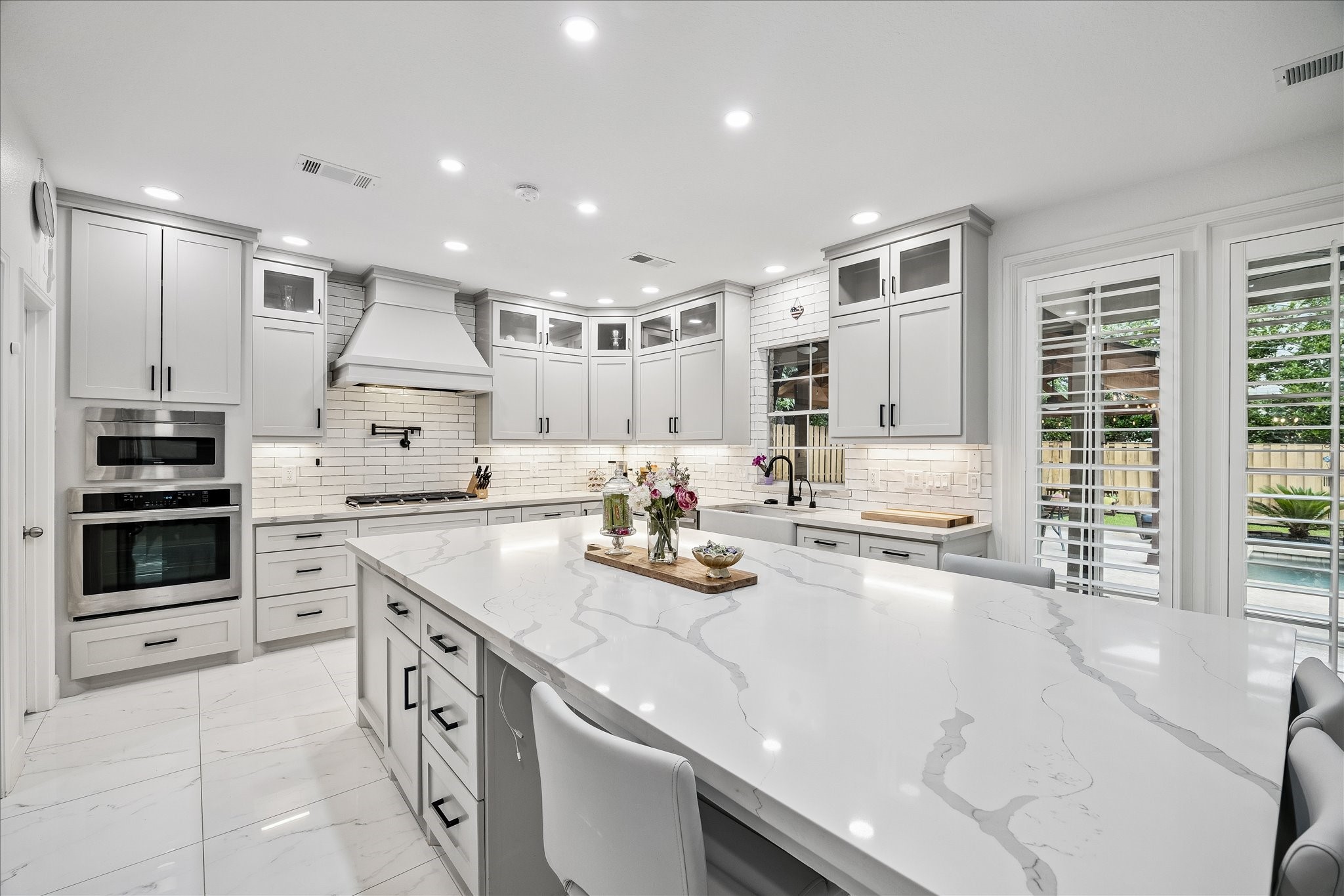 15 West Beckonvale Circle The Woodlands, TX 77382 - Photo 11 of 44 The kitchen has been completely renovated boasting updated cabinetry, quartz countertops, subway tile backsplash, an expansive center island and breakfast bar, & stainless steel appliances.