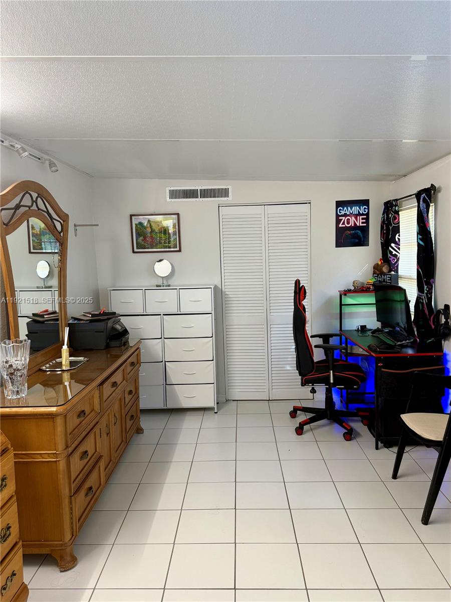 8070 Northwest 176th Street Hialeah, FL 33015 - Photo 17 of 26 a room with furniture a flat screen tv and gym equipment