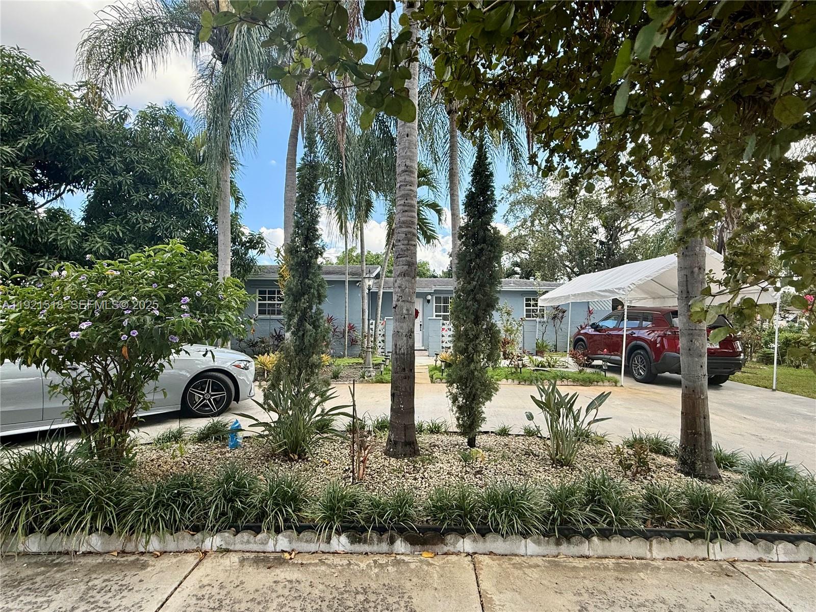 8070 Northwest 176th Street Hialeah, FL 33015 - Photo 2 of 26 a view of a house with a yard and large trees