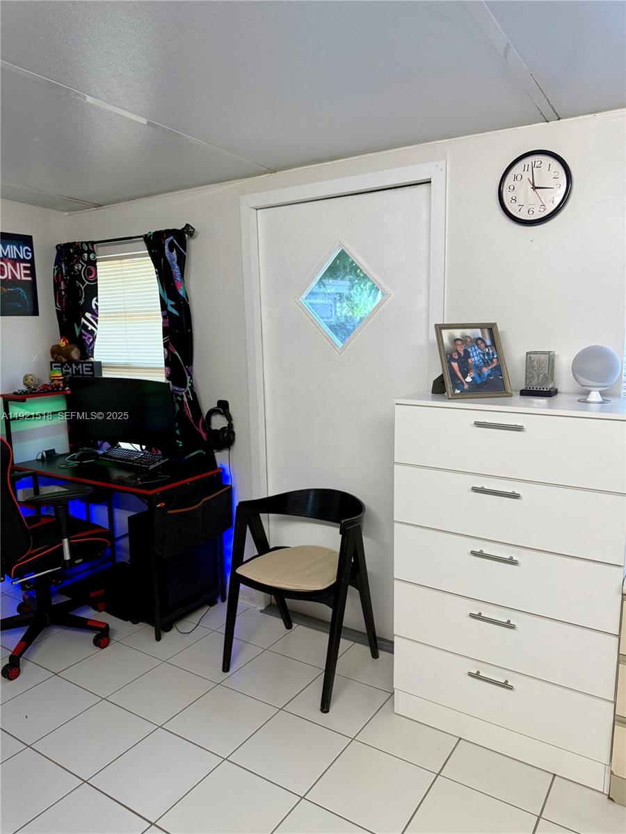 8070 Northwest 176th Street Hialeah, FL 33015 - Photo 22 of 26 a room with a piano and a desk