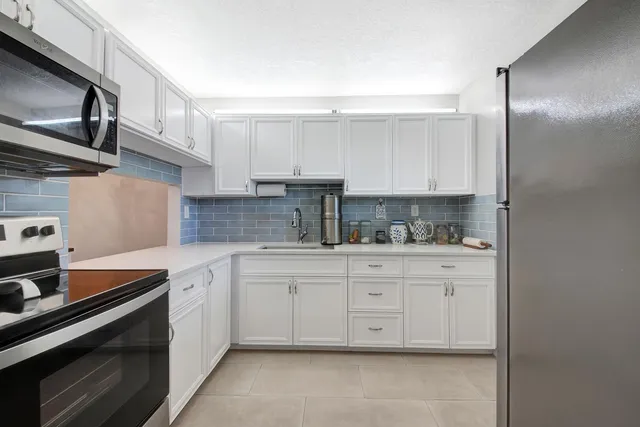 a kitchen with stainless steel appliances granite countertop a sink and cabinets