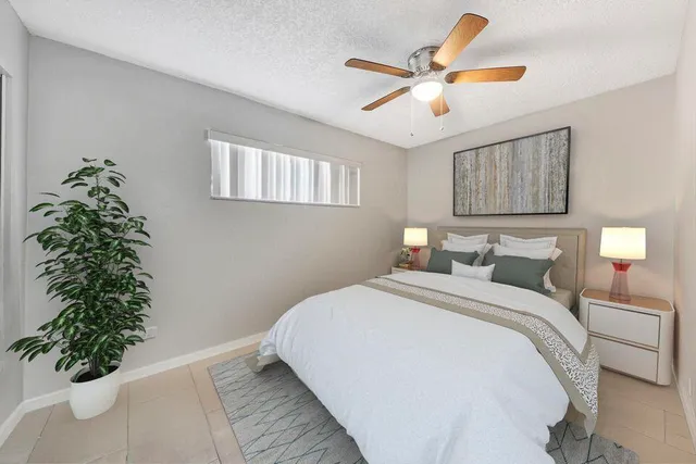 a bedroom with a bed and a potted plant