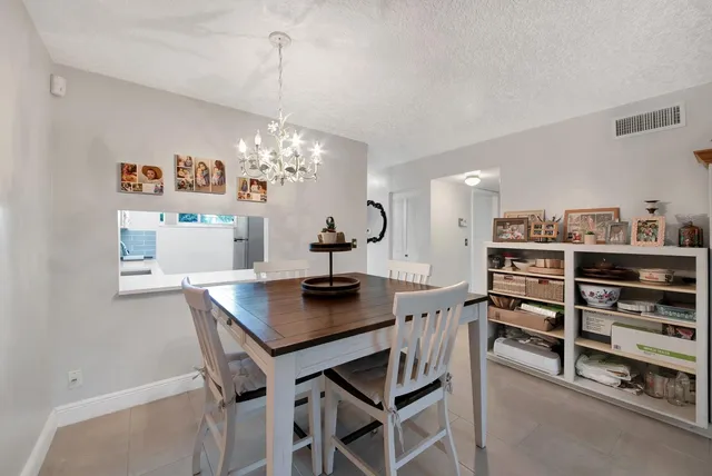 a view of a dining room with furniture and chandelier