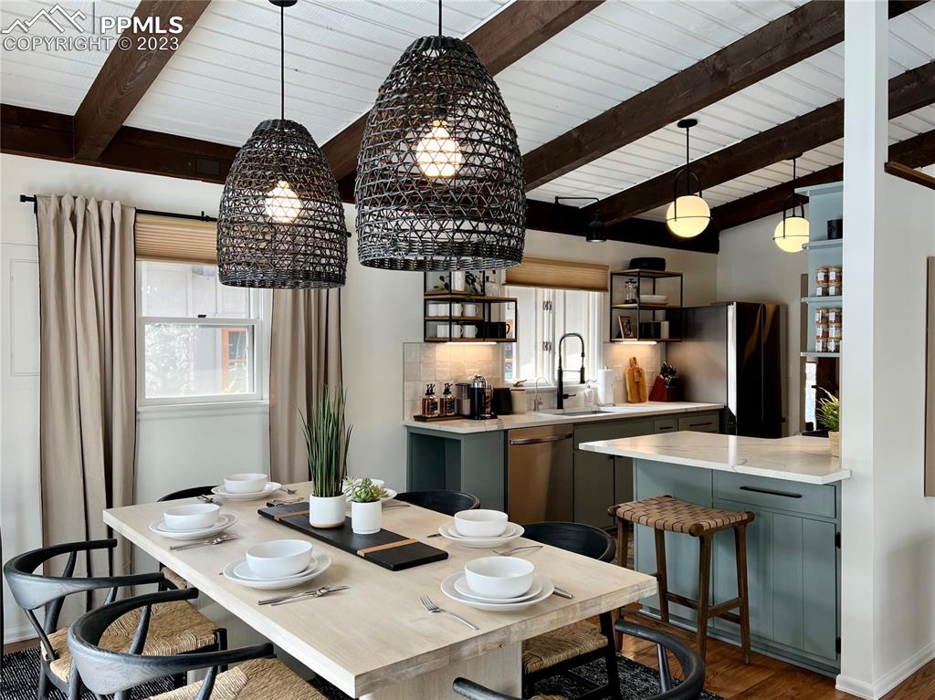 9660 Mohawk Trail Cascade, CO 80809 - Photo 14 of 43 a kitchen with stainless steel appliances kitchen island granite countertop a stove a sink dishwasher and white cabinets with wooden floor