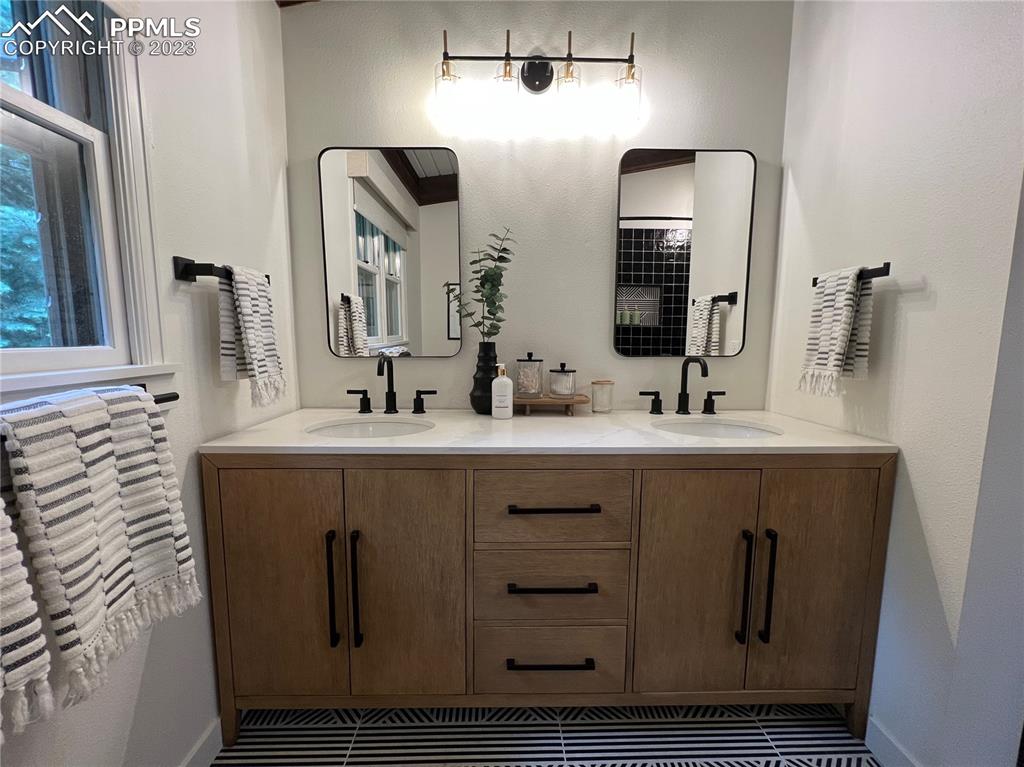 9660 Mohawk Trail Cascade, CO 80809 - Photo 25 of 43 a bathroom with a double vanity sink and mirror