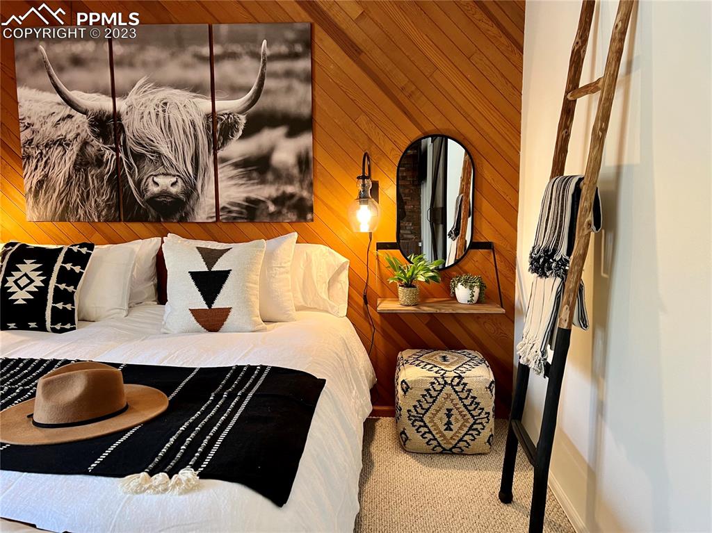 9660 Mohawk Trail Cascade, CO 80809 - Photo 29 of 43 a bedroom with a bed and dresser with wooden floor