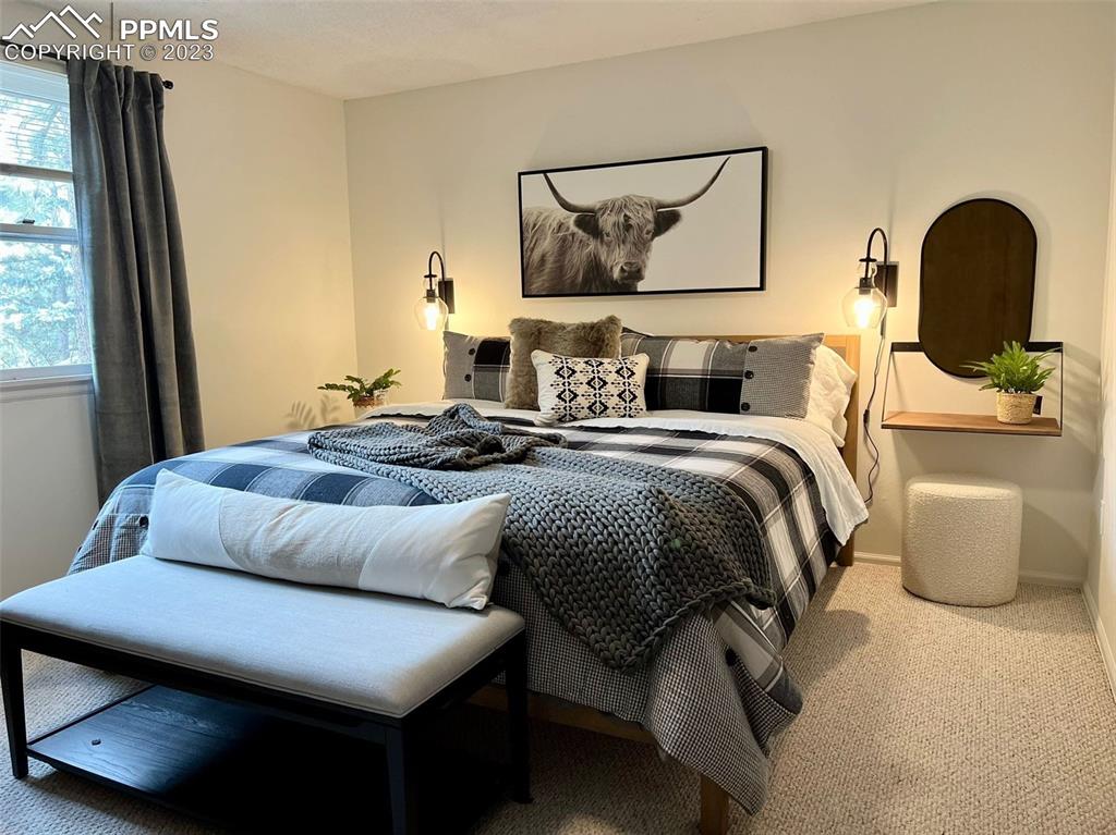 9660 Mohawk Trail Cascade, CO 80809 - Photo 7 of 43 a bedroom with a bed and a painting on the wall