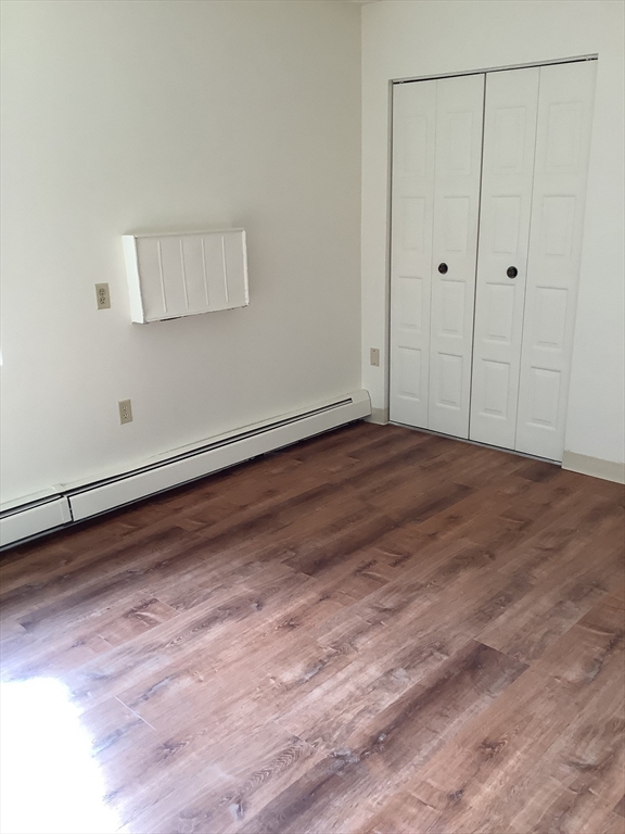 50 Cambridge Road, Unit 110 Woburn, MA 01801 - Photo 5 of 8 a view of an empty room with wooden floor