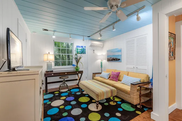 a bedroom with a bed a flat screen tv and a dresser