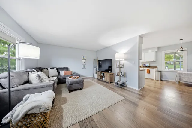 a living room with furniture flat screen tv and a large window