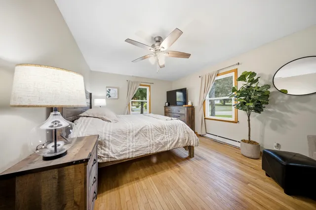 a bedroom with a large bed and wooden floor