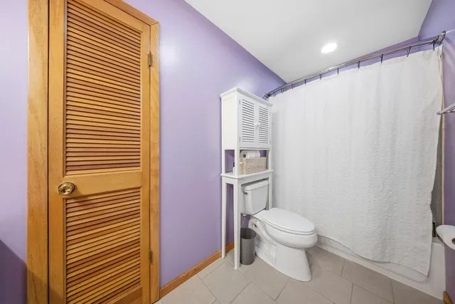 a white toilet sitting next to a shower curtain
