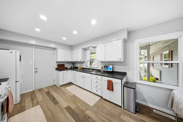 a large kitchen with stainless steel appliances granite countertop a refrigerator and a stove top oven