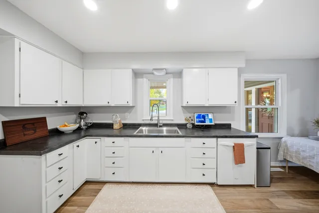 a kitchen with granite countertop white cabinets and white appliances