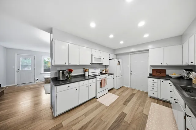 a kitchen with granite countertop a sink a counter top space stainless steel appliances and cabinets