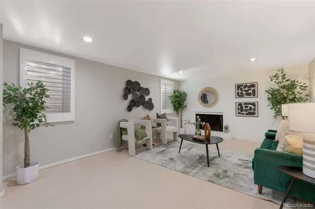 a living room with furniture a window and a potted plant