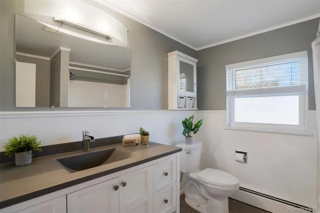 a bathroom with a granite countertop sink a toilet and mirror