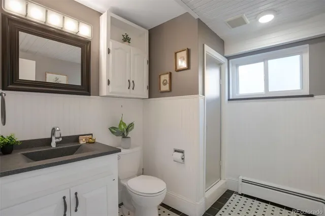 a bathroom with a granite countertop sink a toilet and mirror