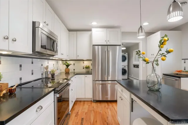 a kitchen with stainless steel appliances a sink a refrigerator a stove a microwave and cabinets
