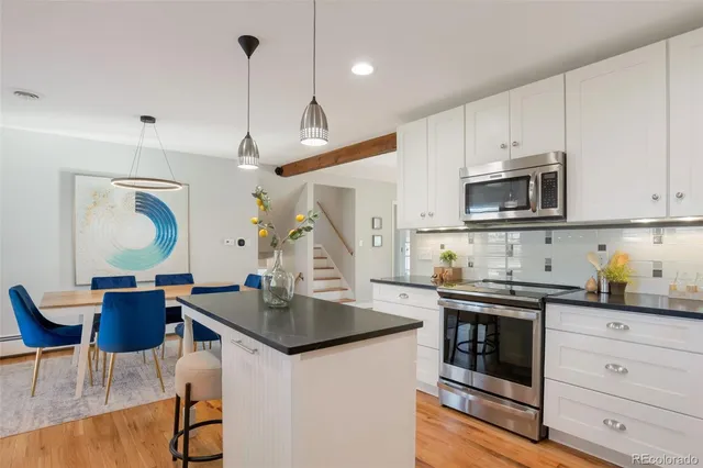 a kitchen with a stove a sink a dining table and chairs