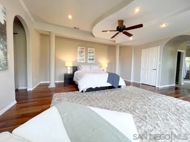 a spacious bedroom with a large bed and a chandelier