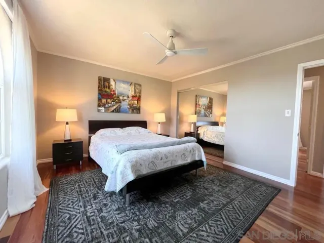 a spacious bedroom with a bed rug and wooden floor