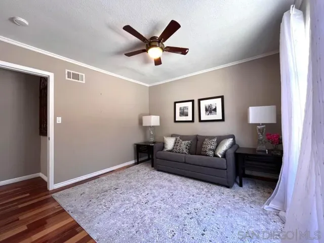 a living room with a couch and a ceiling fan