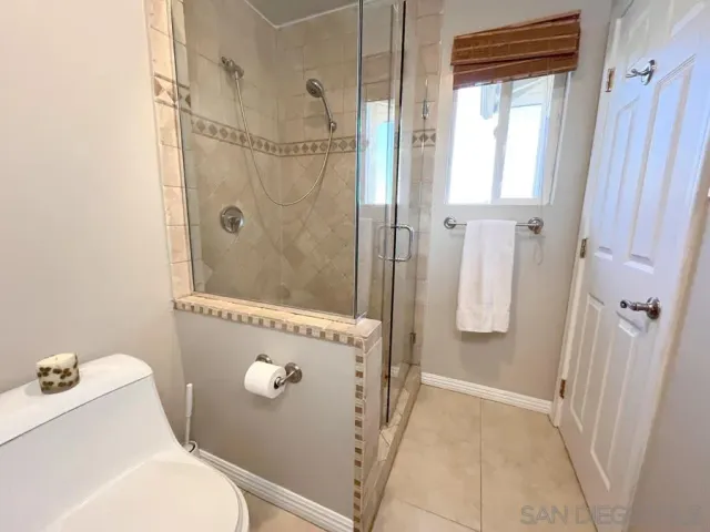 a bathroom with a granite countertop shower and a toilet