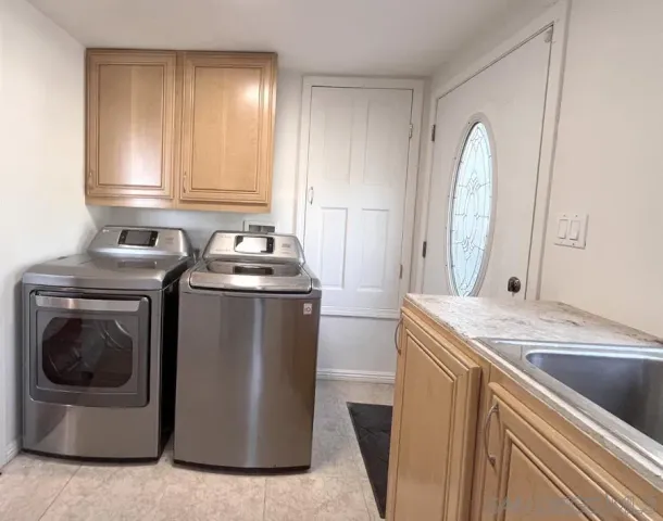 a utility room with sink dryer and washer
