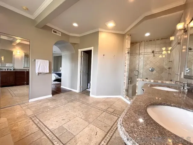 a bathroom with a sink shower and a mirror