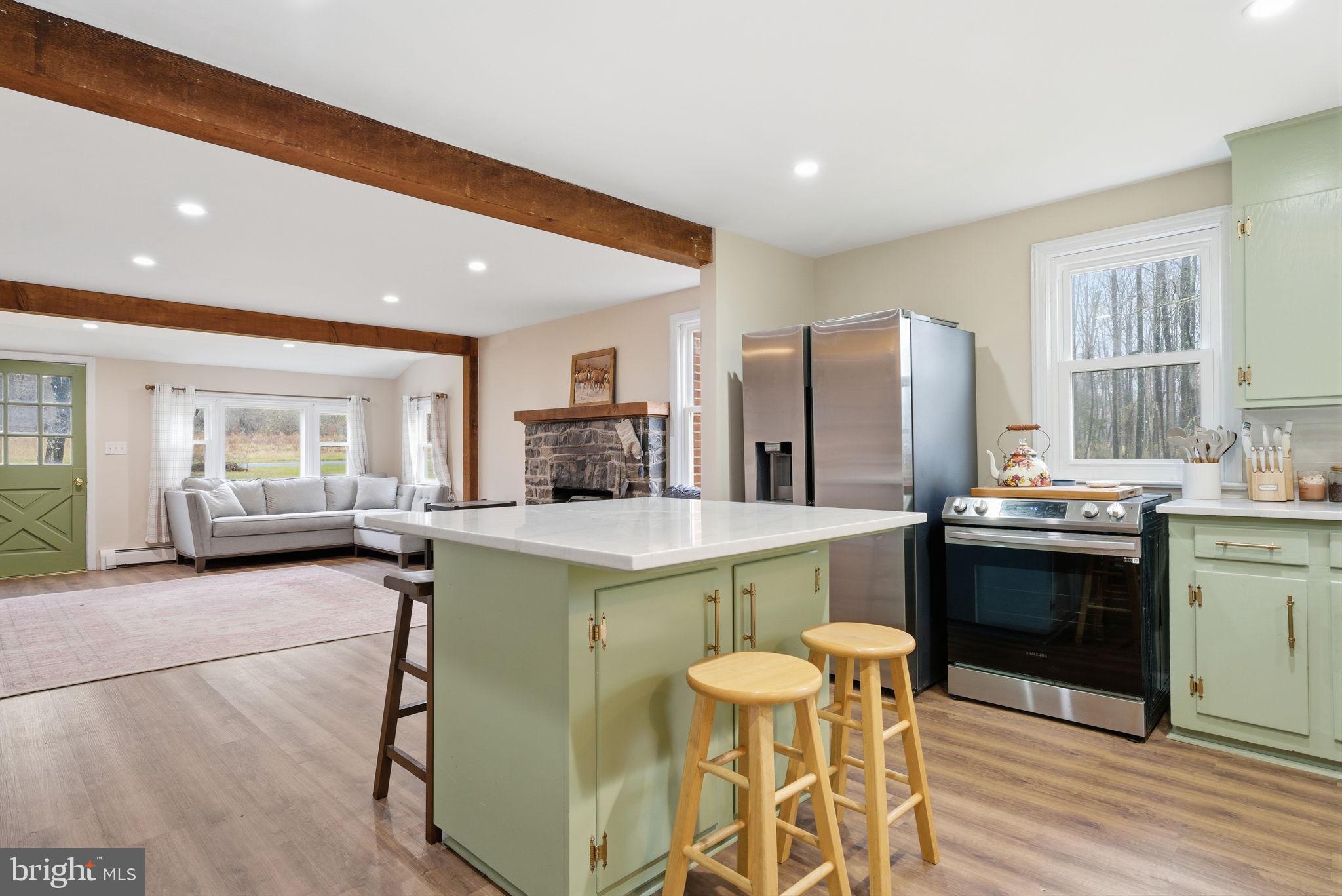 131 Crusher Road Hopewell, NJ 08525 - Photo 11 of 41 a kitchen with a stove a refrigerator and a dining table with wooden floor