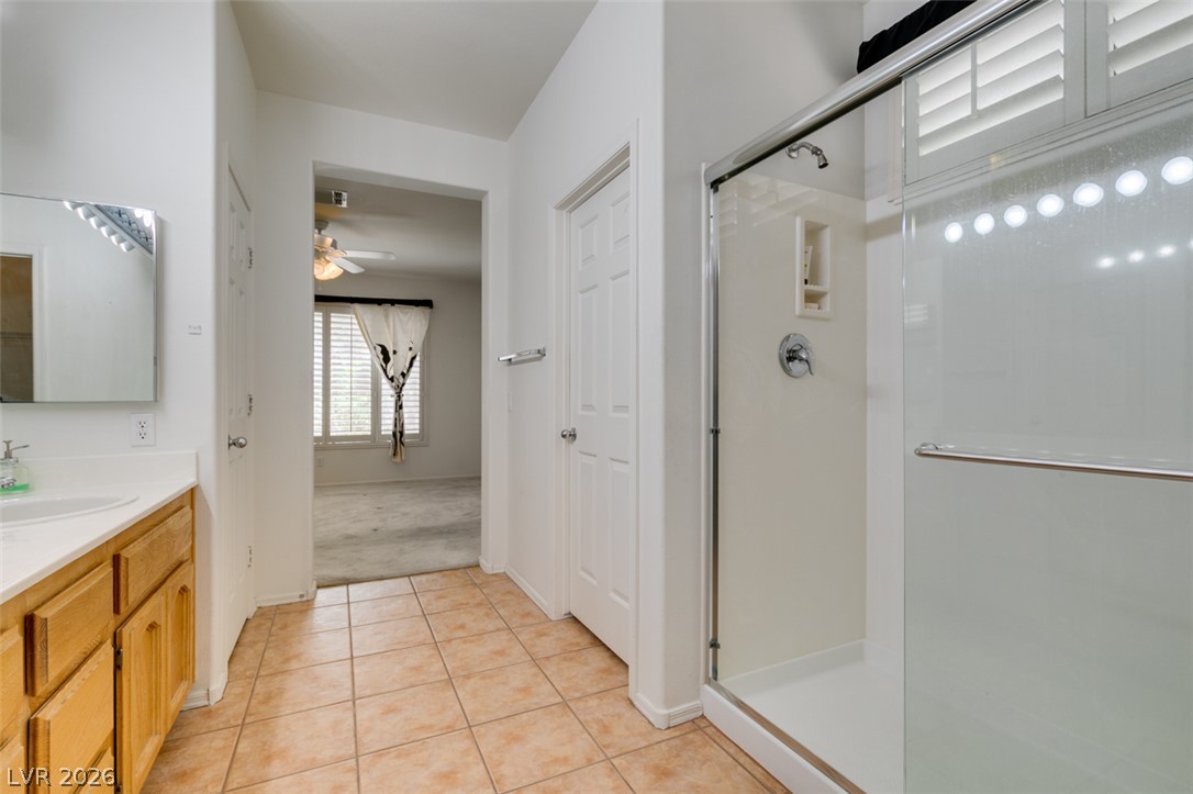 2189 Chapman Ranch Drive Henderson, NV 89012 - Photo 40 of 60 A glass-enclosed shower and tiled flooring define this bathroom which opens to an adjacent bedroom.