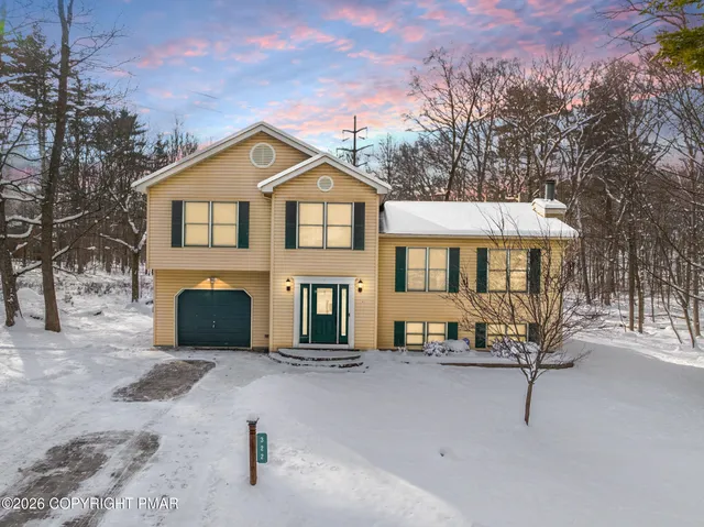 a view of a house with a bench in a yard