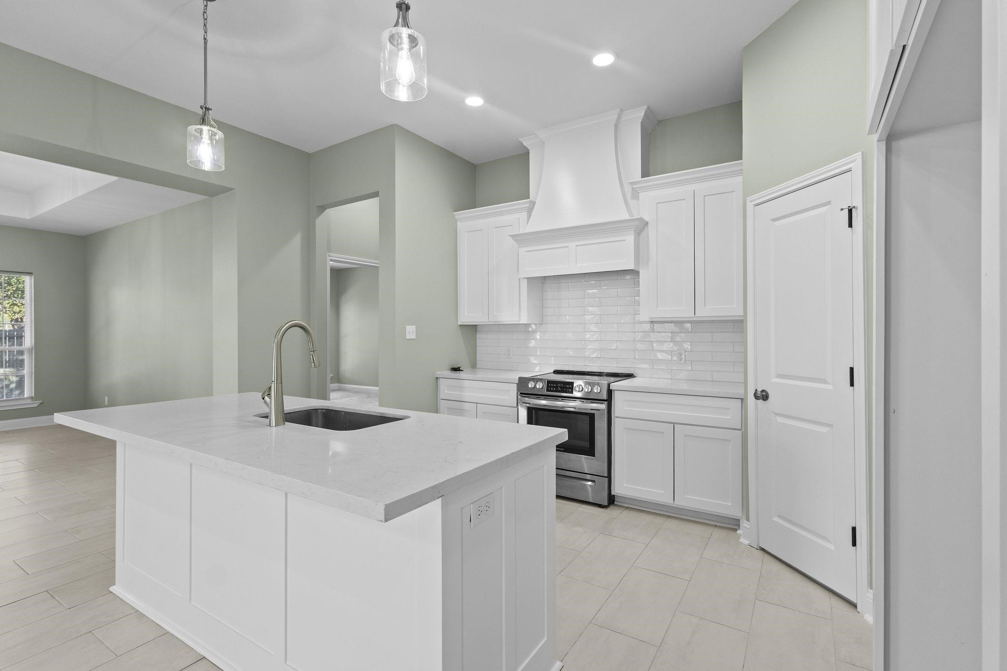 790 Bridgeview Street Bridge City, TX 77611 - Photo 11 of 31 a kitchen that has a sink a stove and chairs