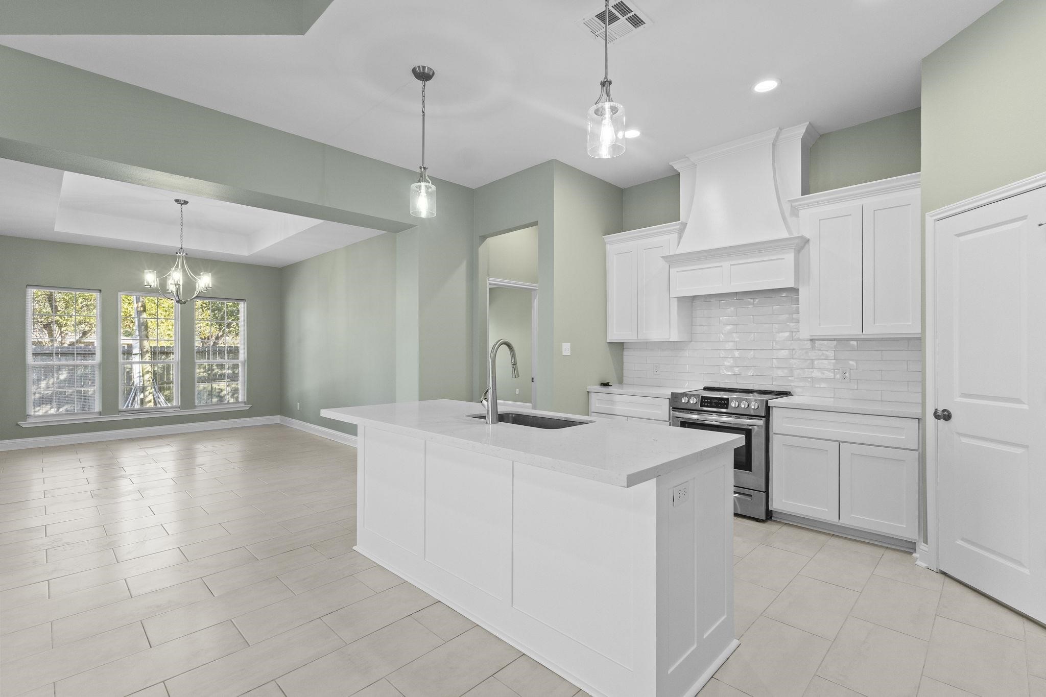 790 Bridgeview Street Bridge City, TX 77611 - Photo 12 of 31 a kitchen with stainless steel appliances granite countertop a sink a stove and a refrigerator