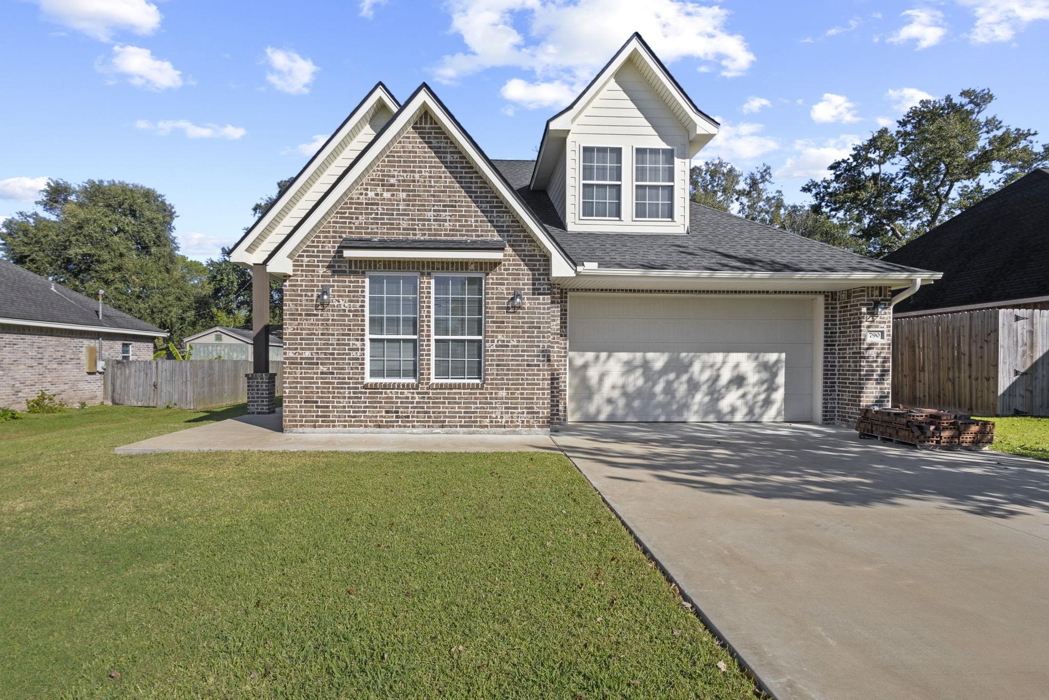 790 Bridgeview Street Bridge City, TX 77611 - Photo 2 of 31 a front view of a house with a yard and garage
